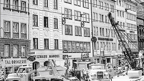 1967 im Tal: Das historische Foto zeigt links einen Kipper von Meiller (nur der hintere Teil des Lkw). Vor Drogerie und Pelzhaus bringt der Kipper Baumaterial in die Innenstadt.