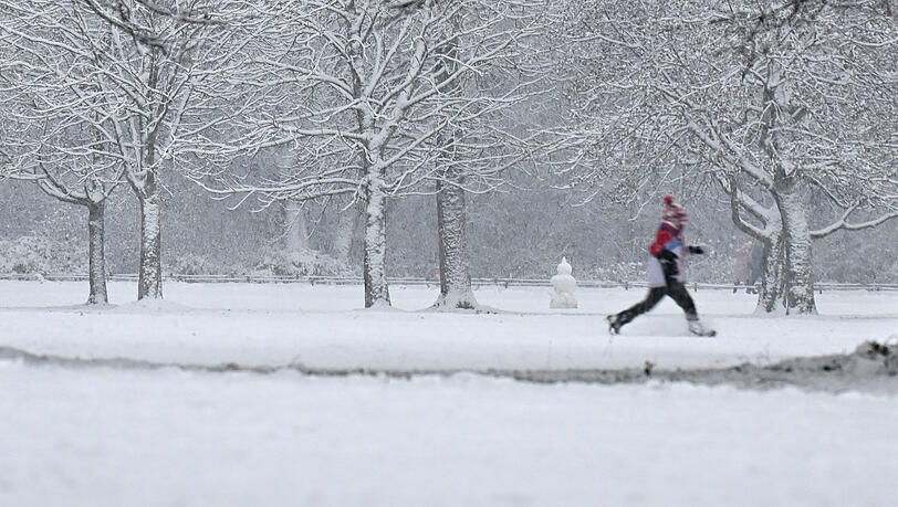Ein Jogger im verschneiten Englischen Garten.