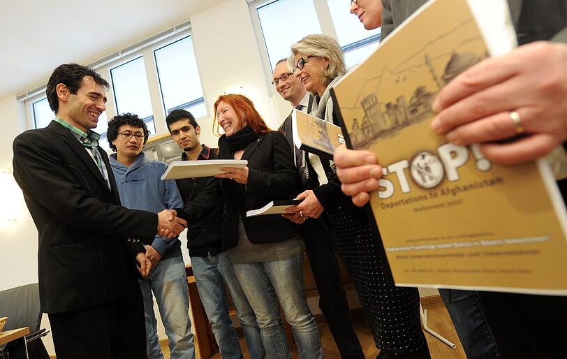Die afghanischen Flüchtlinge Jamal Nasir (l. v. r.), Javad Saberi und Matin Ameri übergeben den Landtagsabgeordneten Renate Ackermann (Grüne), Bernhard Seidenarth (CSU) und Brigitte Meyer (SPD) ihre Petition.