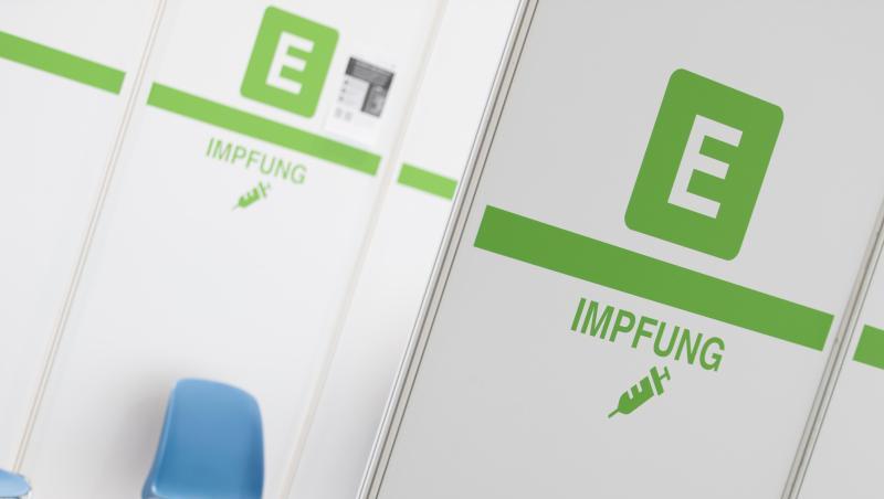 Das Wort &bdquo;Impfung&ldquo; ist an einem Aufsteller zu lesen im Impfzentrum Bielefeld.