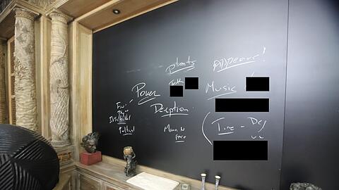 Auf einer Tafel sind die handgeschriebenen Worte "Macht", "Täuschung" und "Wahrheit" zu lesen.