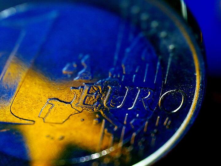 Die Fahne der Europäischen Union (EU) spiegelt sich in einer Euro-Münze. Foto: Oliver Berg/Archiv