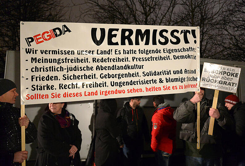 Teilnehmer der islamkritischen Pegida-Bewegung ziehen am 05.01.2015 mit einem Transparent und Fahnen bei einer Kundgebung in Dresden (Sachsen) am Stadion des Fußball-Drittligisten Dynamo Dresden vorbei. Die Pegida hat zu einer erneuten Demonstration in Sachsens Landeshauptstadt aufgerufen.
