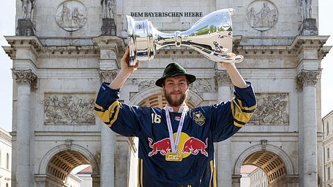 Sieger am Siegestor: Konrad Abeltshauser mit den drei Meisterpokalen des EHC, danach ging die Feier vor dem Eisstadion weiter.