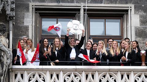 Die Spielerinnen des FC Bayern jubeln mit der Meisterschale auf dem Münchner Rathausbalkon.