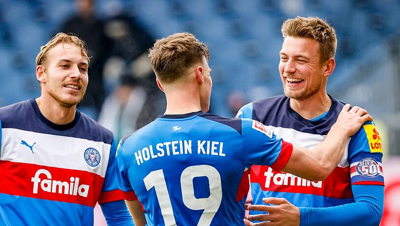 Kiels Timo Becker (l-r), Kiels Simon Lorenz und Kiels Hauke Finn Wahl feiern den Sieg.