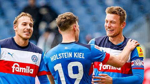 Kiels Timo Becker (l-r), Kiels Simon Lorenz und Kiels Hauke Finn Wahl feiern den Sieg.
