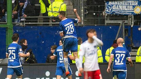Während die Spieler von Darmstadt 98 den Treffer zum 3:2 in Hamburg feiern lässt ein HSV-Spieler den Kopf hängen.