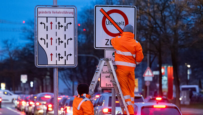 Den orangenen Klebestreifen auf dem Schild haben die zwei Arbeiter am Mittwoch entfernt. Denn ab jetzt gilt in der Innenstadt und dem Mittleren Ring ein Verbot von Euro-4-Dieseln.