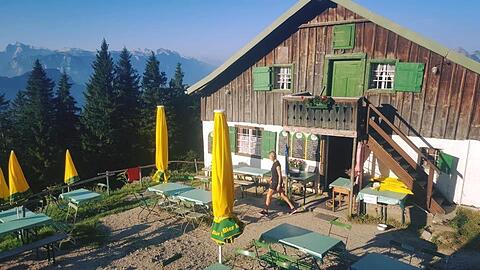 Die Zwieselalm im Sonnenschein. Aktuell liegen dunkle Wolken über der Hütte im Berchtesgadener Land.