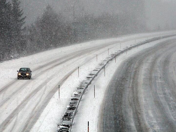 Nicht immer kann geräumt werden: Ein einsames Auto auf einer schneebedeckten Autobahn.