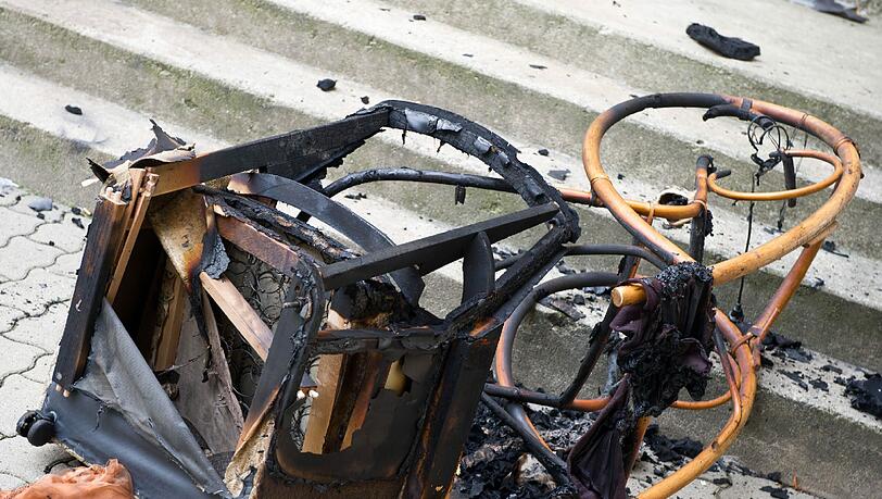 Ein verbrannter Sessel und ein Schaukelstuhl liegen am Samstag vor dem Treppenaufgang eines Plattenbaus in Frankfurt (Oder). Ein verbrannter Sessel und ein Schaukelstuhl liegen am Samstag vor dem Treppenaufgang eines Plattenbaus in Frankfurt (Oder).