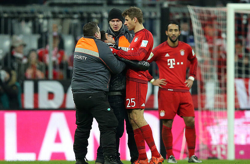 Ein Flitzer umarmt Thomas Müller. Der Bayern-Star bleibt völlitg gelassen, die Security greift ein.