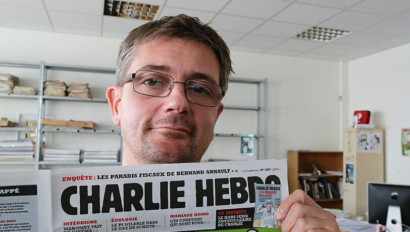 Der Zeichner und Redakteur Charb gestern in seiner Redaktion, umringt von Kamerateams. Er steht jetzt unter Polizeischutz, wie die gesamte Redaktion. Der Zeichner und Redakteur Charb gestern in seiner Redaktion, umringt von Kamerateams. Er steht jetzt unter Polizeischutz, wie die gesamte Redaktion.