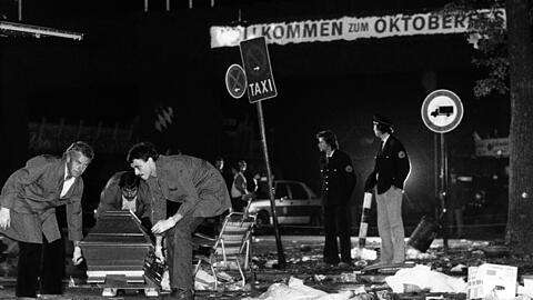 Eines der erschütternden Bilder vom 26. September 1980: Ein Sarg wird vom verwüsteten Tatort weggetragen.