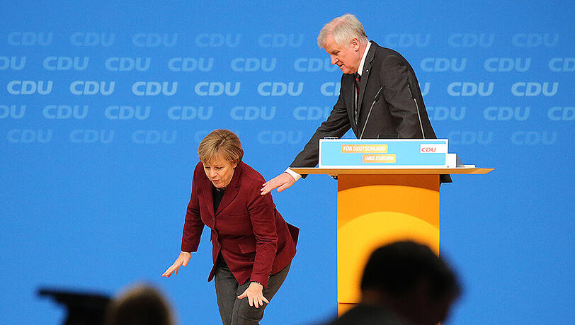 Horst Seehofer greift nach Angela Merkel, die beim gemeinsamen Auftritt am Dienstag auf der Bühne stolperte. Der bayerische Ministerpräsident bemühte sich in Karlsruhe um die Demonstration von Geschlossenheit mit der Schwesterpartei und der Bundeskanzlerin. Horst Seehofer greift nach Angela Merkel, die beim gemeinsamen Auftritt am Dienstag auf der Bühne stolperte. Der bayerische Ministerpräsident bemühte sich in Karlsruhe um die Demonstration von Geschlossenheit mit der Schwesterpartei und der Bundeskanzlerin.