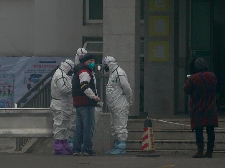 Mitarbeiter in Schutzanzügen vor dem Wuhan Medical Treatment Center in Wuhan, in dem ein Patient mit Verdacht auf den neuartigen Corona-Virus behandelt wurde.