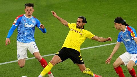 Dortmunds Emre Can (M) kommt vor Kiels Fabian Reese (l) an den Ball.