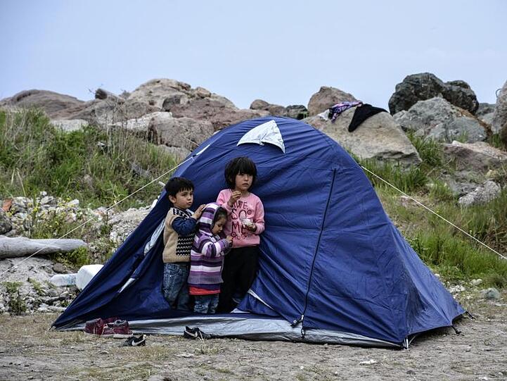Kinder vor einem Zelt im Dorf Petra auf der nordöstlichen Ägäisinsel Lesbos.