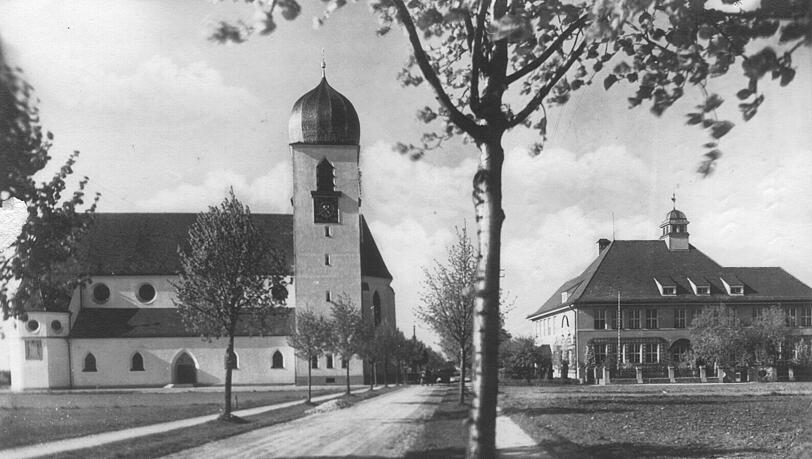 Die 1950 noch unbefestigte Grandlstraße mit Pfarrkirche und Schule. Die 1950 noch unbefestigte Grandlstraße mit Pfarrkirche und Schule.