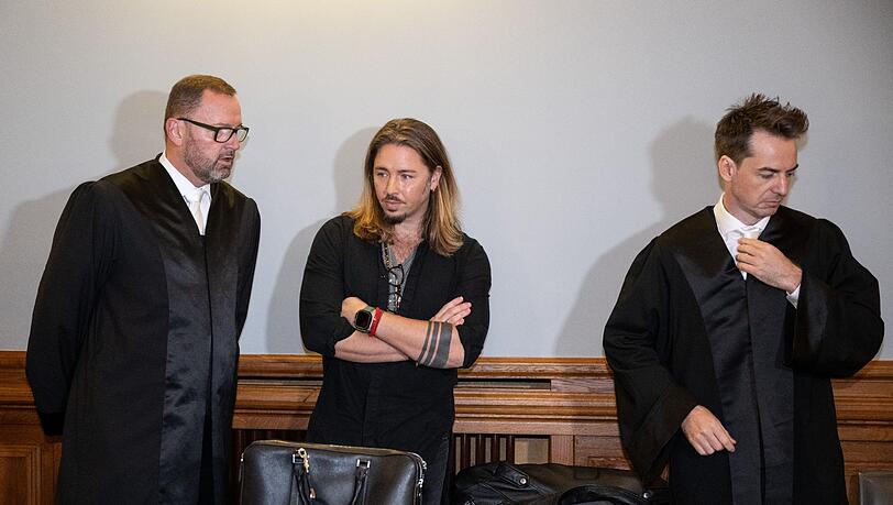 Gil Ofarim (M) steht im Saal des Landgerichts in Leipzig zwischen seinen Anwälten.