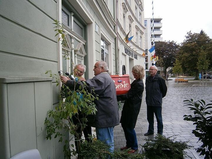Mit vereinten Kräften wird der Briefkasten aufgehängt.