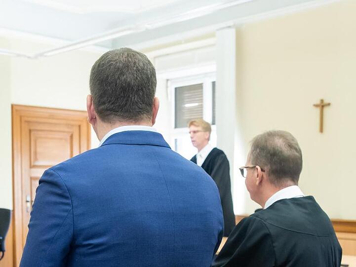 Ein wegen Störung der Totenruhe angeklagter Bestatter (l) steht mit seinem Anwalt Ulrich Spieß in einem Sitzungssaal. Foto: Daniel Karmann
