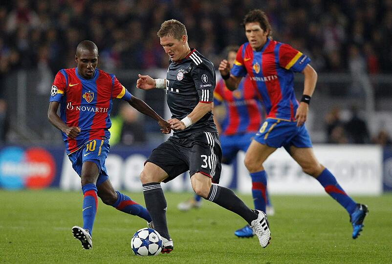 Wiedersehen mit dem FC Basel: Hier kämpft Bayern Münchens Bastian Schweinsteiger (Mitte) gegen Gilles Yapi. Szene aus dem Champions-League-Vorrundenspiel im September 2010 in Basel.
