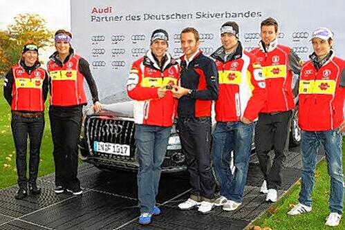 Gruppenbild mit Dienstfahrzeug: DTM-Champion Timo Scheider bei der symbolischen Schlüsselübergabe an Ski-Jäger Michael Greiß (Mitte). Links Kati Wilhelm und Maria Riesch, rechts Felix Neureuther Björn Kircheisen und Martin Schmitt.