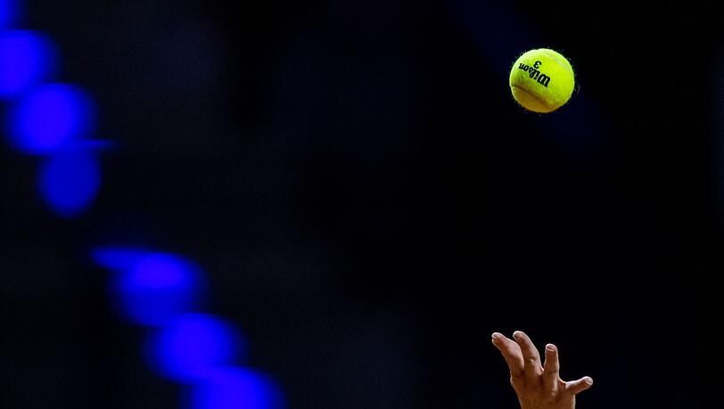 Ein Tennisball wird in die Luft geworfen.