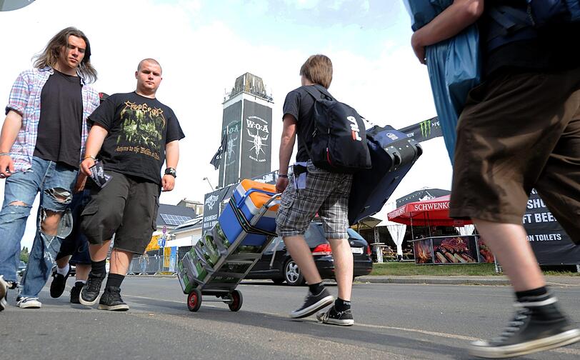 ...seit Tagen mit Metal-Fans überfüllt. Sie transportieren ihr Gepäck zum Festival-Gelände und...