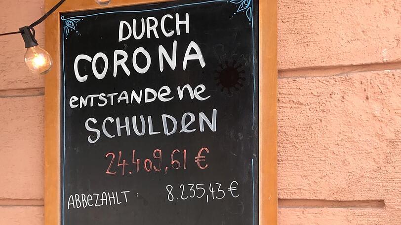Ludwigsvorsadt-Isarvorstadt - Auf dem Kreideschild vor dem Mucki & Floyd in der Ickstattstraße stehen derzeit keine Tagesgerichte. Statt einer Tagesempfehlung gibt?s rote Zahlen. Satte 24.409,61 Euro Miese (Stand 16.Juli) machte das Café wegen der Coronakrise. Und diese roten Zahlen könnten noch anwachsen. 
Zwar gab?s für das Mucki & Floyd Soforthilfe, erklärt Betreiberin Helena Hellmann gegenüber der AZ. Dass die Soforthilfe nicht reicht, um die Verbindlichkeiten zu decken, braucht keine Erklärung. &bdquo;Miete, Strom, Versicherung &ndash; alles kostet extra&ldquo;, so Hellmann. Stundungen helfen auch nicht, da die Kosten dann zu einem späteren Zeitpunkt auflaufen.  
Schuldentafel vor dem Mucki&Floyd