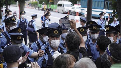 Demonstranten wurden vor Beginn der Olympia-Schlussfeier in Tokio von Polizisten aufgehalten.