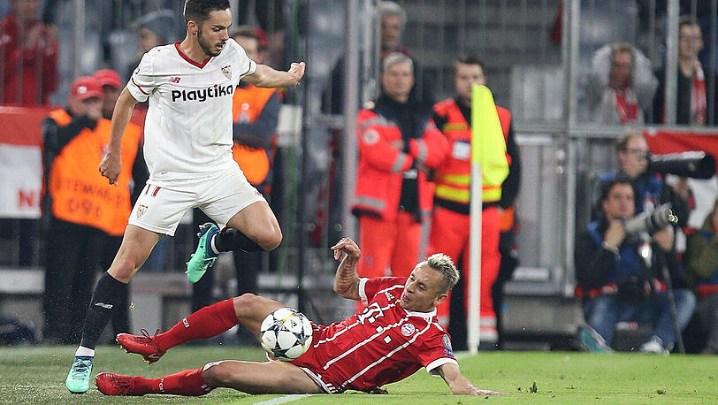 Bayerns Alaba-Ersatz Rafinha fährt Pablo Sarabia vom FC Sevilla in die Parade.
