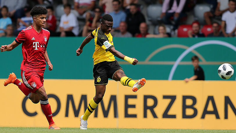 Malik Tillman vom FC Bayern (links) kommt im Duell mit dem Dortmunder Youssoufa Moukoko einen Schritt zu spät.