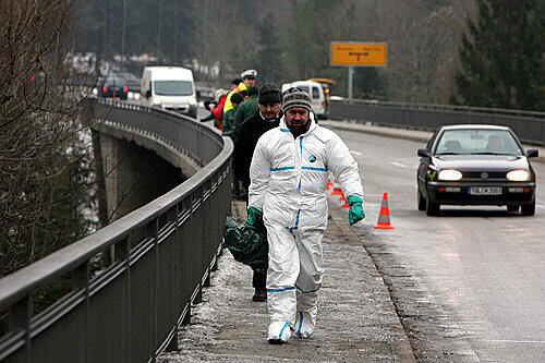 Ein Mitarbeiter der Spurensicherung läuft über die Tattenkofener Brücke.