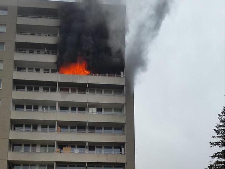 Feuerwehrleute stehen mit einem Löschzug vor einem Brennenden Hochhaus. Foto: Freiwillige Feuerwehr Puchheim-Bahnhof