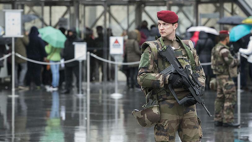 Mit Maschinengewehren bewaffnete Polizisten sichern nach der Attacke das Gebiet um den Pariser Louvre.