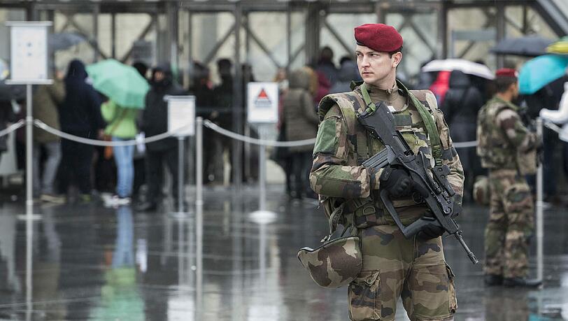 Mit Maschinengewehren bewaffnete Polizisten sichern nach der Attacke das Gebiet um den Pariser Louvre. Mit Maschinengewehren bewaffnete Polizisten sichern nach der Attacke das Gebiet um den Pariser Louvre.