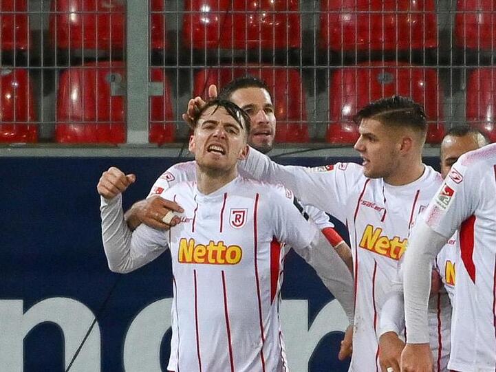 Die Mannschaft von Regensburg jubelt nach dem Elfmeter-Treffer von Max Besuschkow.. Foto: Armin Weigel/dpa