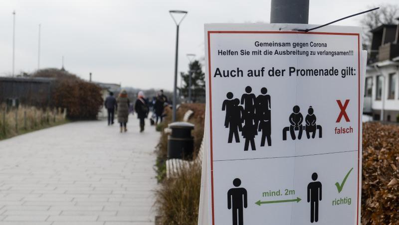 "Gemeinsam gegen Corona": Ein Schild an einer Promenade weist darauf hin, dass der Abstand eingehalten werden muss. "Gemeinsam gegen Corona": Ein Schild an einer Promenade weist darauf hin, dass der Abstand eingehalten werden muss.