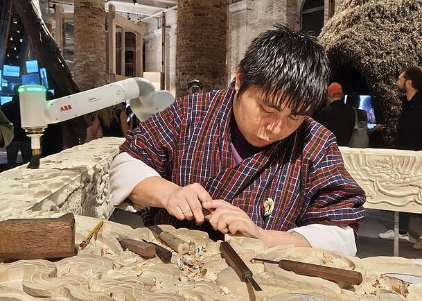 Der Roboter adaptiert, was der junge Kunsthandwerker aus Bhutan mühsam in einen mächtigen Holzbalken schnitzt. Der Roboter adaptiert, was der junge Kunsthandwerker aus Bhutan mühsam in einen mächtigen Holzbalken schnitzt.