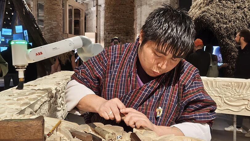 Der Roboter adaptiert, was der junge Kunsthandwerker aus Bhutan mühsam in einen mächtigen Holzbalken schnitzt. Der Roboter adaptiert, was der junge Kunsthandwerker aus Bhutan mühsam in einen mächtigen Holzbalken schnitzt.