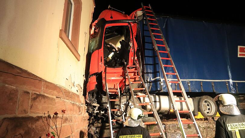 Der Sattelzug rammte ein geparktes Auto und donnerte gegen ein Haus. Die Rettung des Fahrers gestaltete sich extrem kompliziert.