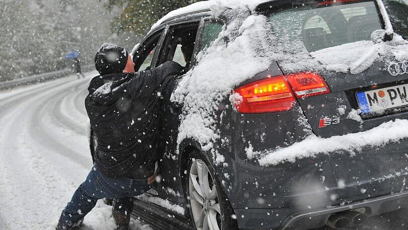 Dieser Mann versucht verzweifelt, auf der abschüssigen Straße am Spitzing sein rutschendes Auto zu stoppen. Dieser Mann versucht verzweifelt, auf der abschüssigen Straße am Spitzing sein rutschendes Auto zu stoppen.