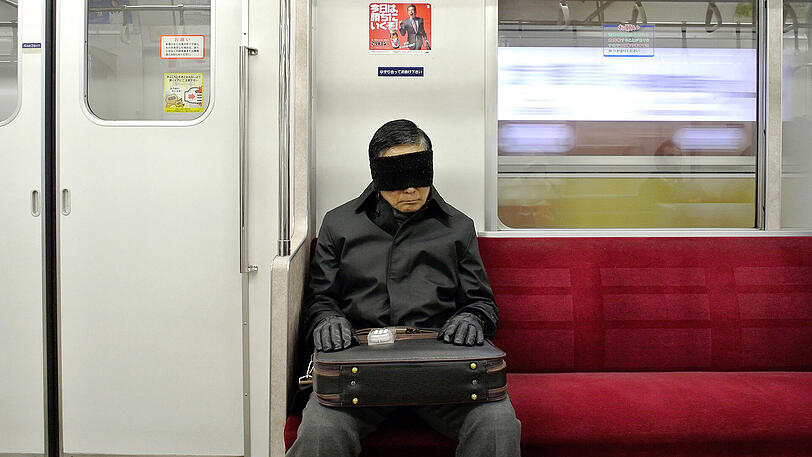 Mit Schlafmaske macht dieser Mann ein Nickerchen in der Tokioter U-Bahn. Klassische Musik soll nun ebenfalls für entspannte U-Bahn-Fahrten sorgen.