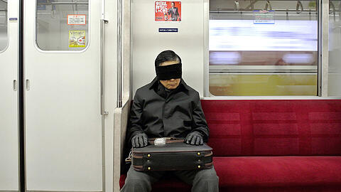 Mit Schlafmaske macht dieser Mann ein Nickerchen in der Tokioter U-Bahn. Klassische Musik soll nun ebenfalls für entspannte U-Bahn-Fahrten sorgen.