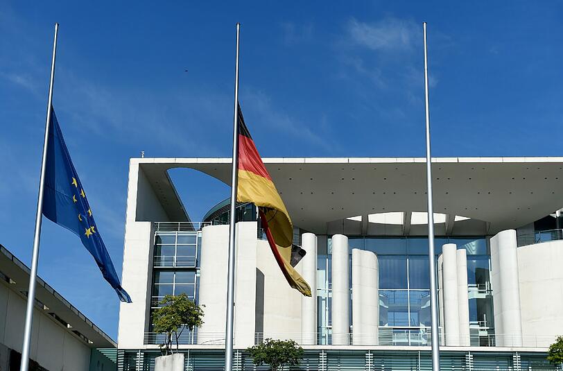 Die deutsche und die europäische Flagge hängen vor dem Bundeskanzleramt in Berlin auf Halbmast.