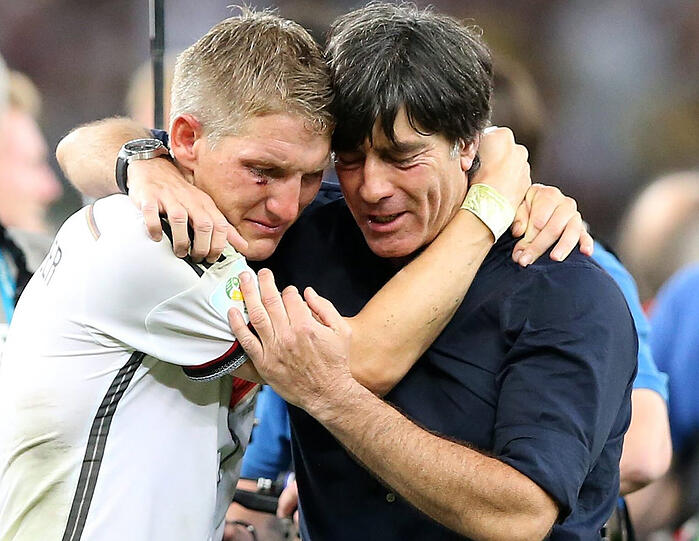 Der Höhepunkt seines Schaffens und in den Armen von Bundestrainer Joachim Löw: Schweinsteiger krönt sich 2014 zum Weltmeister.