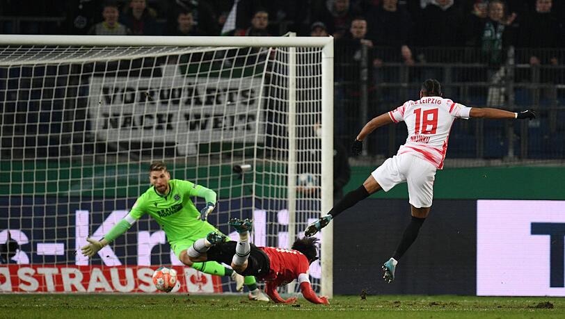 Christopher Nkunku (r) trifft zur 1:0-Führung gegen Hannovers Torwart Ron-Robert Zieler.